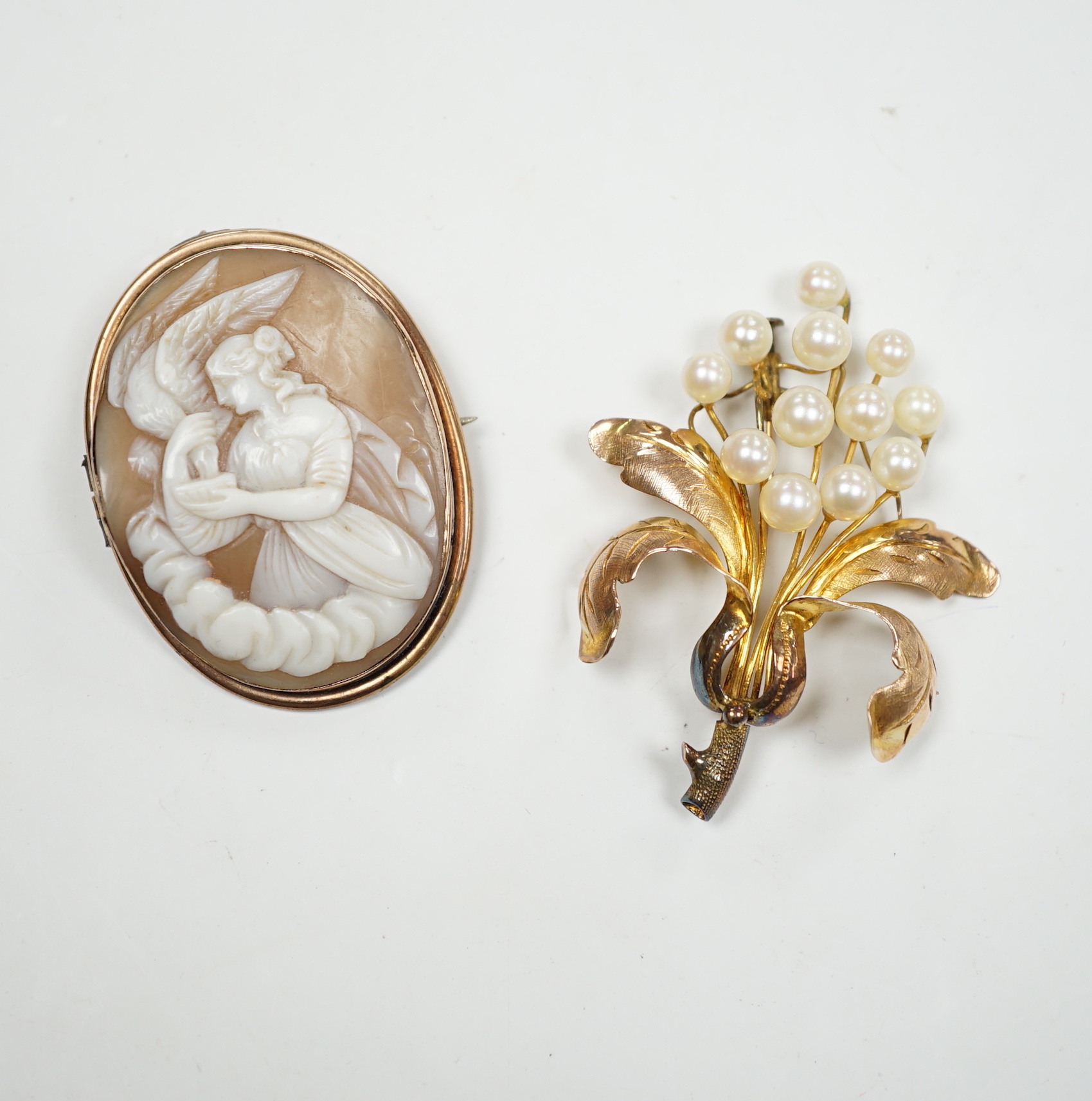 A 14K yellow metal and cultured pearl cluster set floral brooch, 52mm, gross weight 7 grams, together with a yellow metal mounted carved cameo shell brooch.